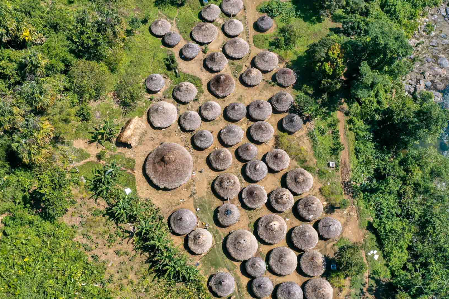 Vista aérea de un poblado kogui en la Sierra Nevada de Santa Marta: casas circulares de techo cónico de paja entre la vegetación.